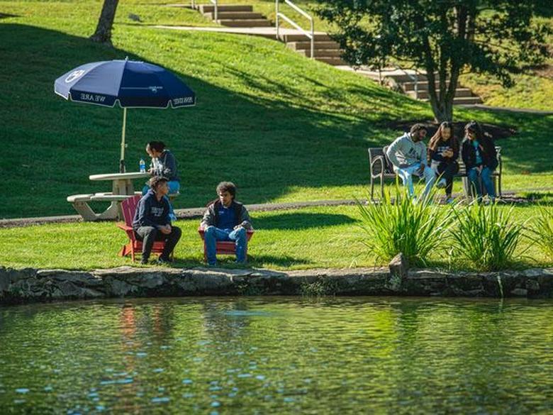 students sitting in front of Lares pond at Penn State Abington (near Philadelphia)